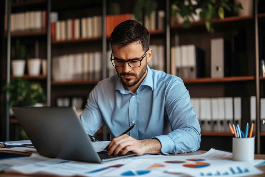 DISC Leadership Model: A Clear, Practical Guide for Hiring and Team Success 1 A detail-oriented leader analyzing financial reports in a structured workspace.