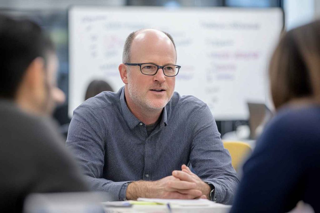 What Are Leadership Styles? How Many Are There: 5, 6, or 7? 1 A business leader facilitating a collaborative discussion with employees, representing democratic leadership.