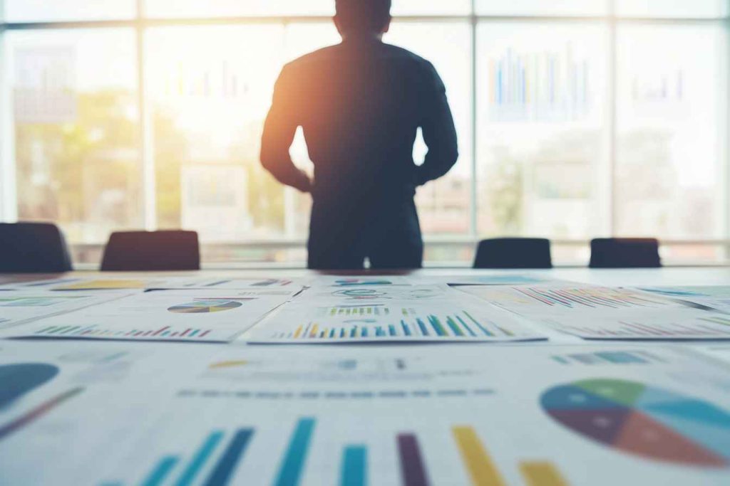 A male digital marketing manager leading a strategy meeting with his team in a corporate conference room.