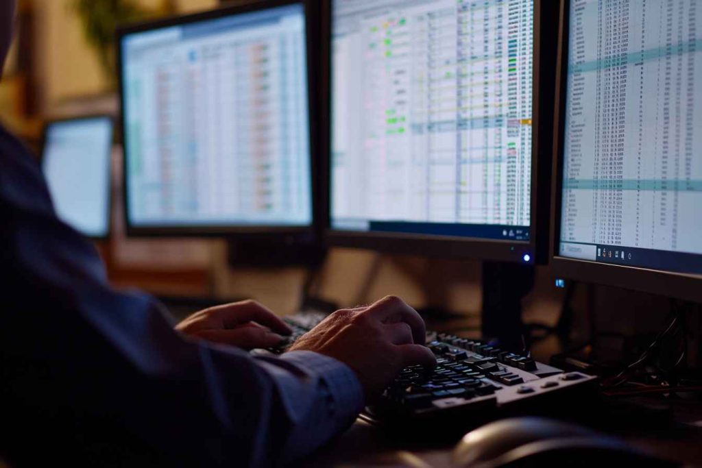 dual-monitor-data-entry-setup Man working efficiently on dual monitors during a data entry task
