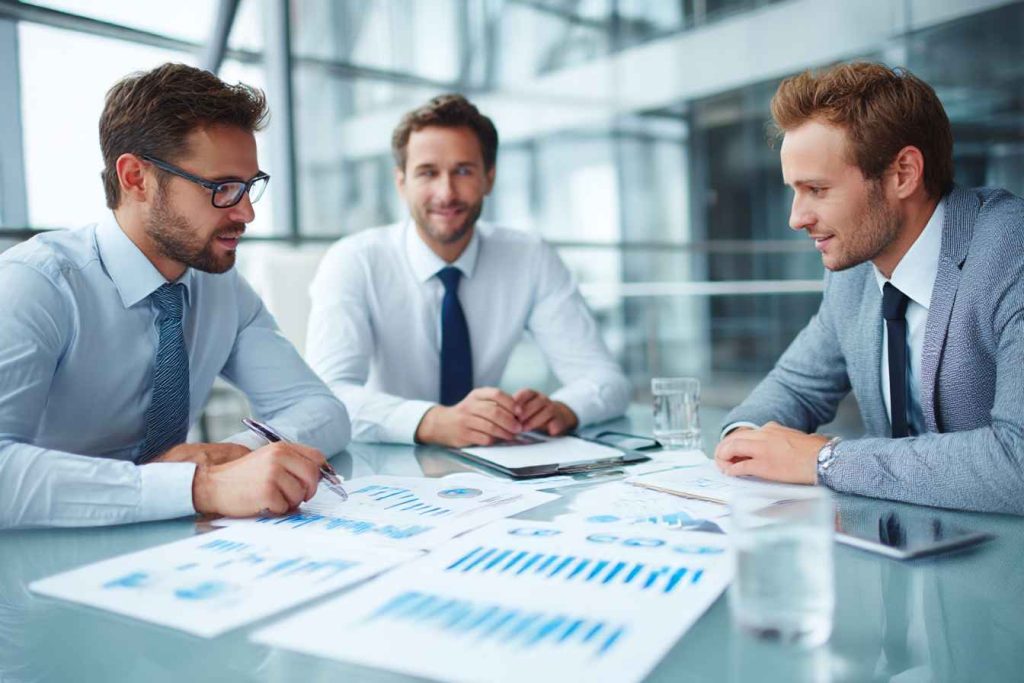 Finance hiring team discussing candidate test scores in meeting room