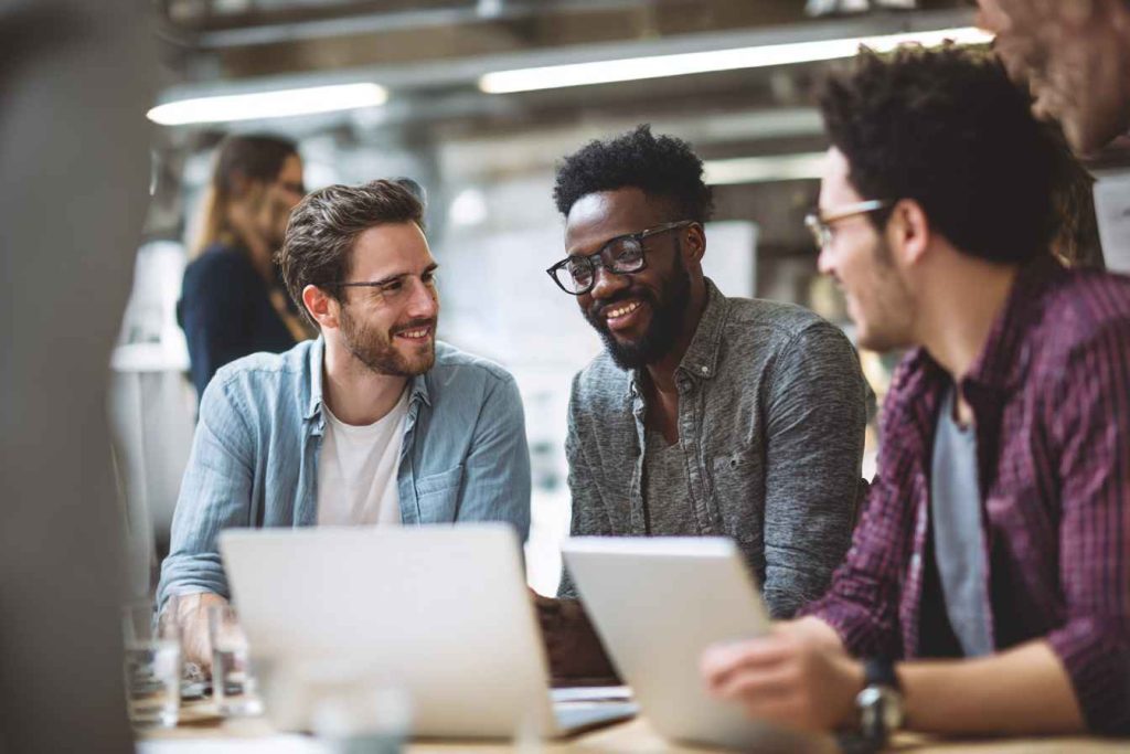 Best Automated Reference Check Software Solution for Modern Hiring Teams 1 A diverse hiring team collaborating and smiling while using modern hiring software